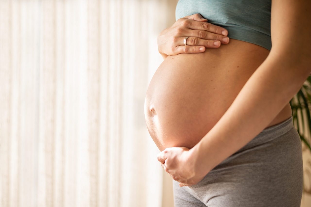 Pregnant woman embracing her belly